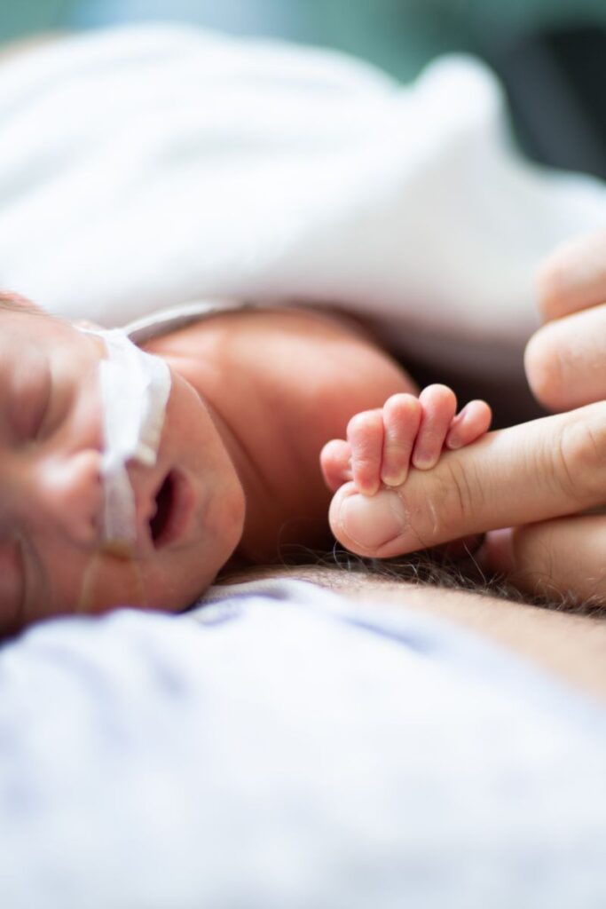 Newborn holding mom finger